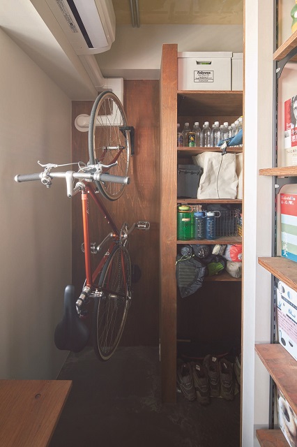 書斎の一角にご主人が使う登山の道具や自転車を収納するスペースを設けた。ミネラルウォーターのストックなどもここに