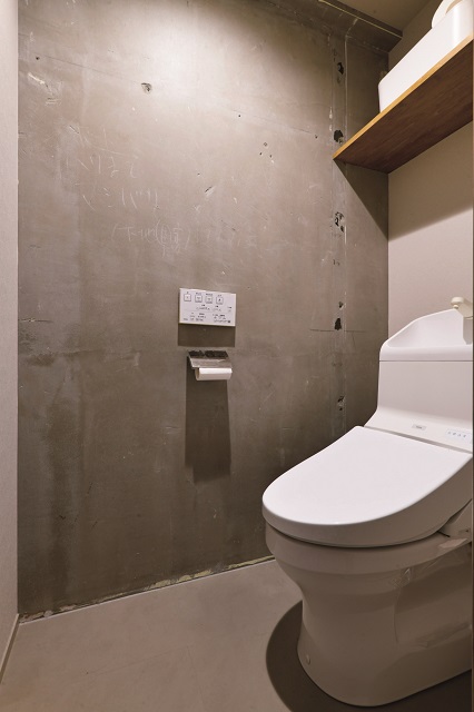 建物の壁際に移設したトイレ。躯体現しにした壁には、マンション建設時に書かれたメモ書きが残されてあり、ユニークなアクセントとして楽しんでいる