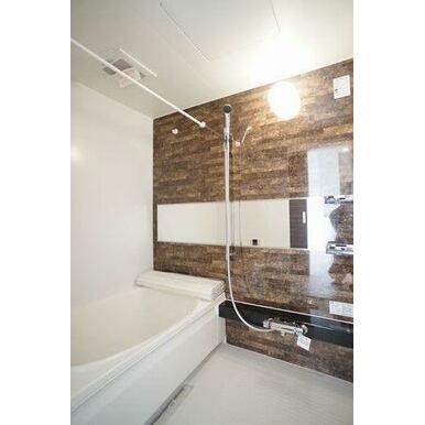 石目調のアクセントパネルの付いた浴室です。高級感の中で疲れを癒してください