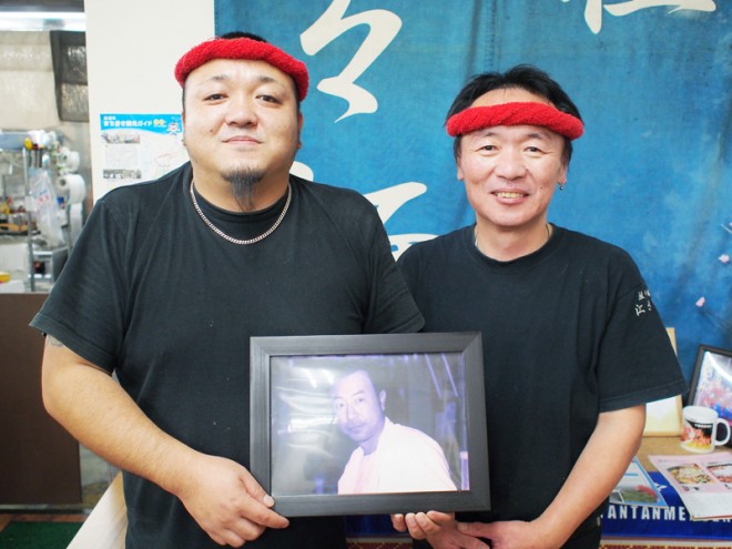 店長の江澤文彦さん（右）と、息子の正紀さん（左）。額縁の写真は初代店長の勉さん。親子三代が勢揃い。